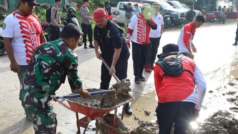 Bupati Kukar, Edi Damansyah sedang membersihkan lumpur di badan jalan