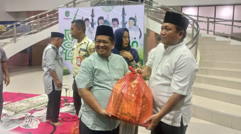Kepala Dispora Kukar, Aji Ali Husni menyerahkan zakat saat acara Khatam Al Quran