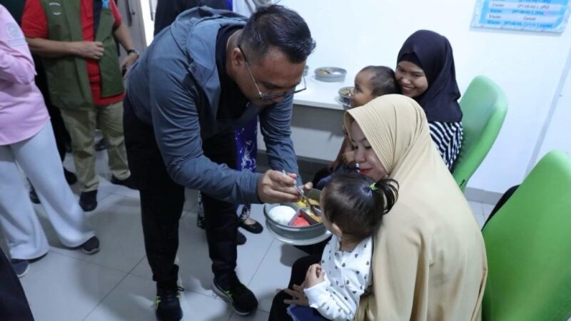 Bupati Kukar, Aulia Rahman Basri melakukan Pemberian Makanan Tambahan (PMT) kepada balita dan ibu