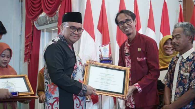 Kepala Desa Kota Bangun III menerima penghargaan dari Bupati Kukar, aulia Rahman Basri