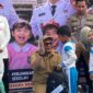 Bupati Kutai Kartanegara Aulia Rahman Basri menyerahkan seragam sekolah gratis bagi siswa di Tenggarong (Latif/Eksposisi)